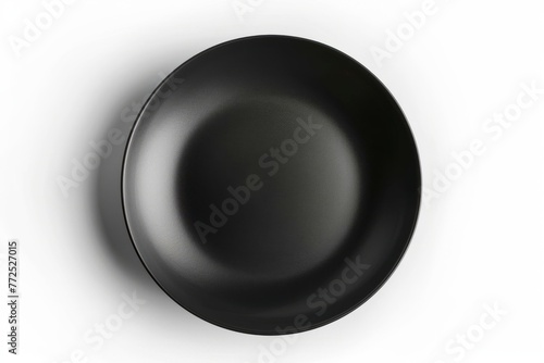 A sleek black plate, set against a white backdrop. Top view epty ceramic dish isolated on white background. photo