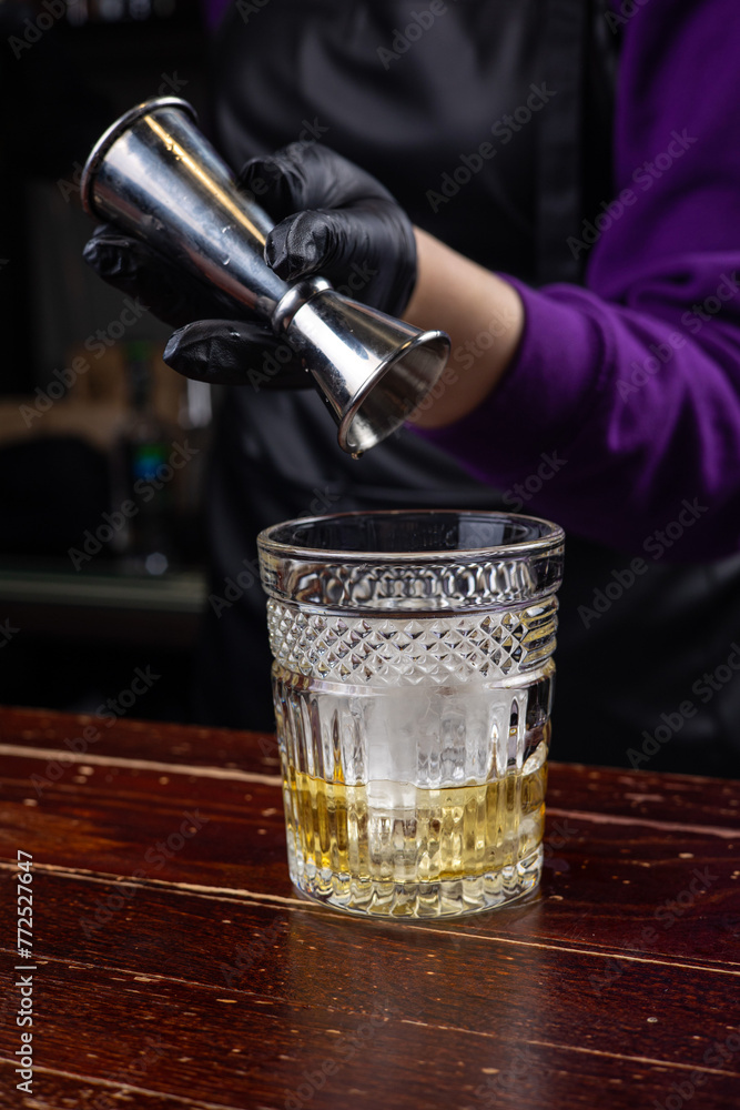 a bartender prepares a negroni cocktail a bartender prepares a negroni cocktail