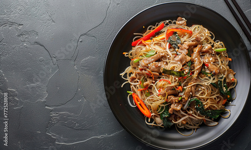 japchae, Stir fry noodles with pork and vegetable in black plate, copy space, korean food, restaurant advertising 