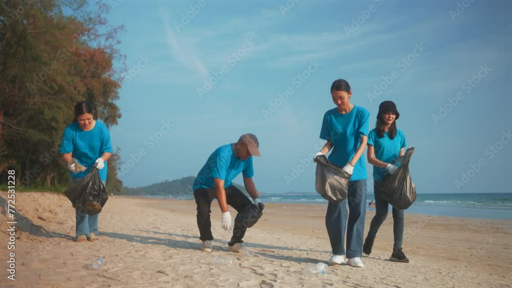 Plastic pollution and environmental problem concept. Happy asian diverse group of volunteers with garbage bags wearing blue t-shirt and cleaning plastic on the beach. Volunteers collecting trash. Plastic pollution and environmental problem concept. Happy asian diverse group of volunteers with garbage bags wearing blue t-shirt and cleaning plastic on the beach. Volunteers collecting trash.