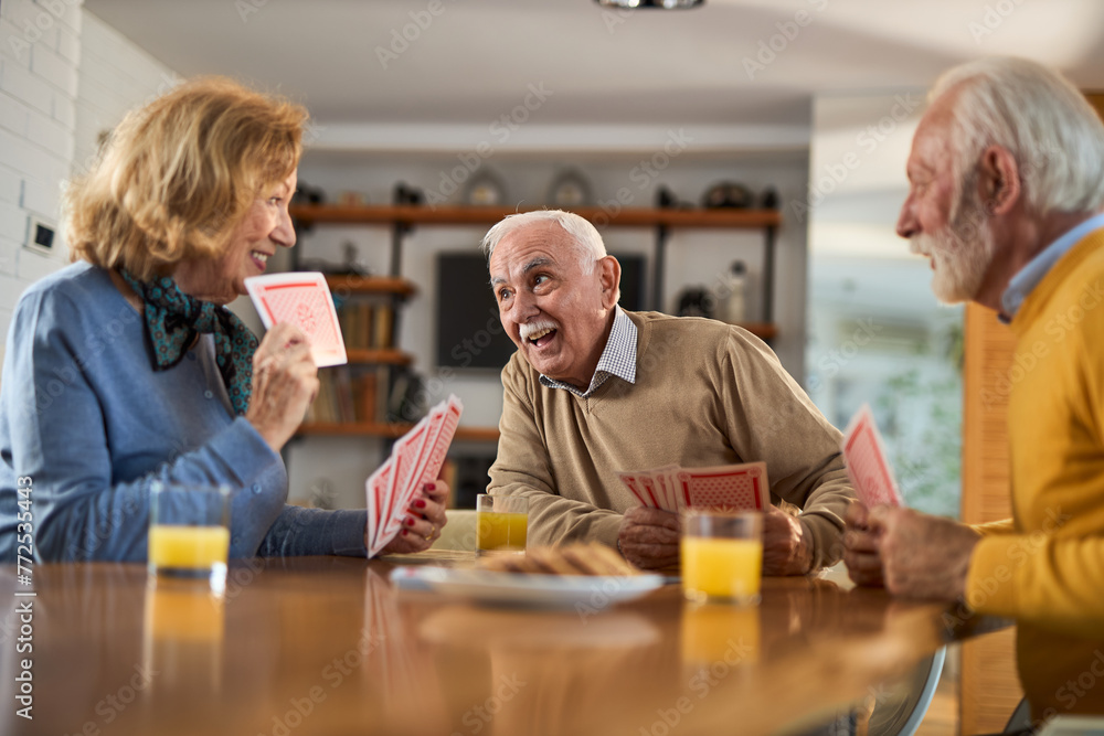 Group of happy seniors having fun while playing cards at home. Group of happy seniors having fun while playing cards at home.