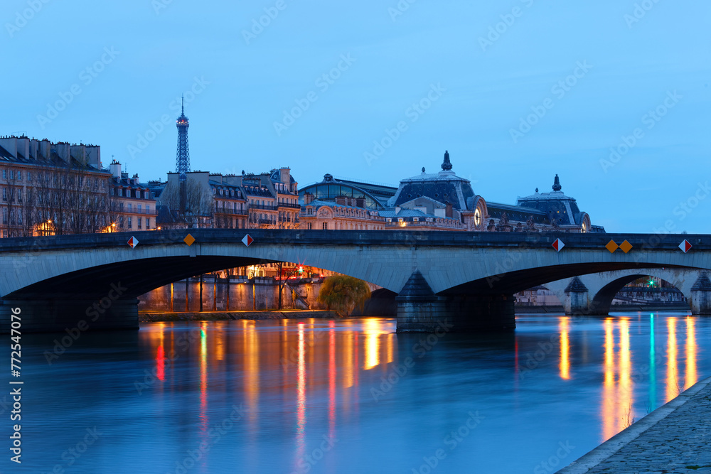Obraz premium Night view of the banks of the Seine in Paris, France, with Carrousel bridge , Ouai Voltaire and beautiful sky and reflections