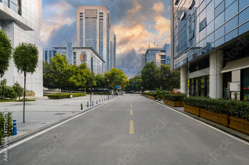 Modern Business District Urban Street Scene with Contemporary Buildings, Reflective Glass Facades, and Dramatic Skyline photo