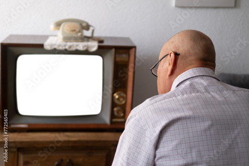 elderly man turns on and watches old retro analog TV with blank screen for designer, white background, 1960-1970, stylish mockup, template for video, Retro Technology in Everyday Life