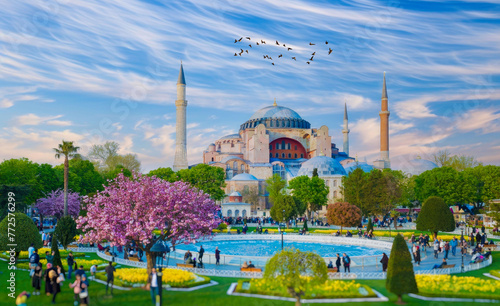 Majestic Hagia Sophia in Istanbul, Turkey, with Dynamic Sky and Blooming Park with Visitors and Birds Flying. photo