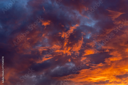 Dramatic fiery bloody sky with orange, red and purple fluffy clouds at sunset