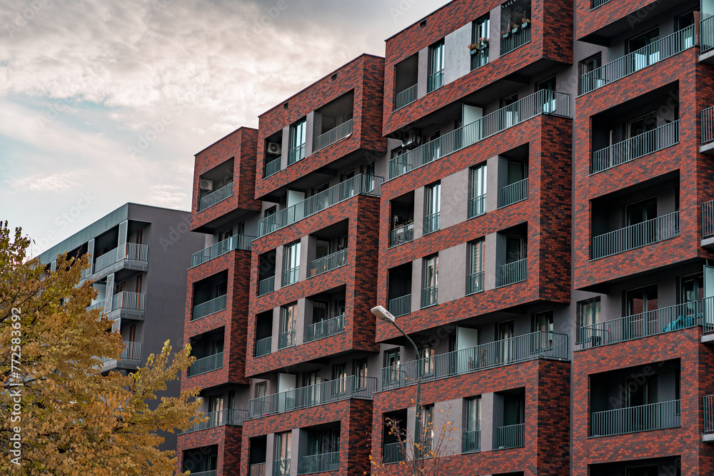 Residential building or hotel facade with brick frames on balcony, modern condominium
