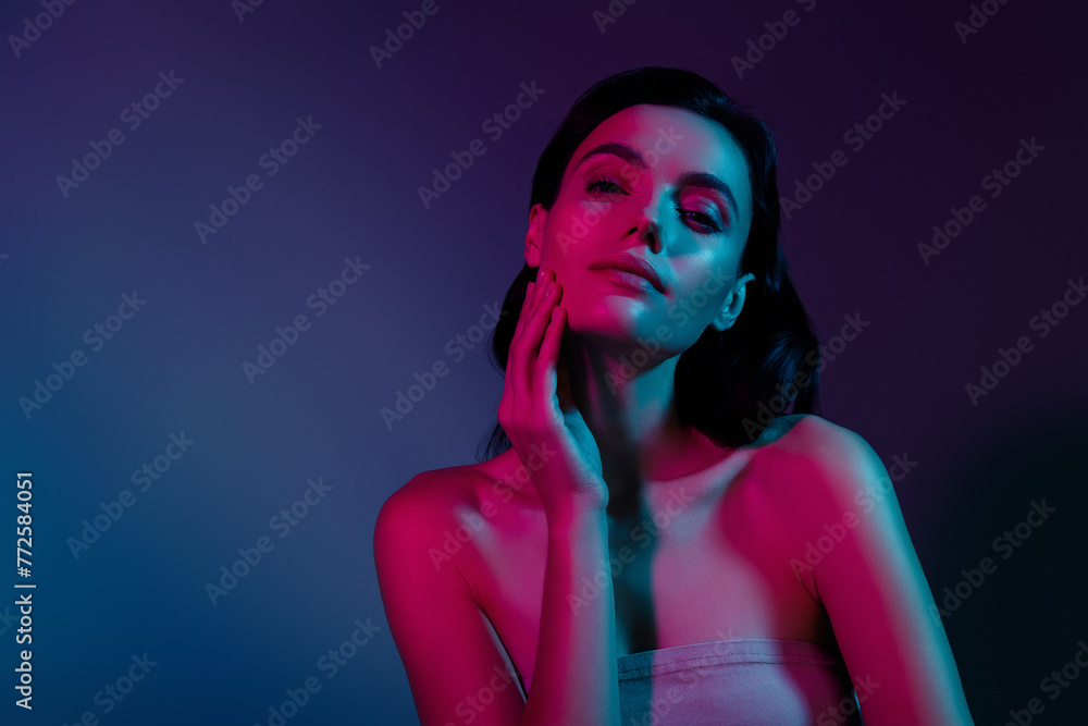 Photo of woman touch face skin on cheeks under pink neon light isolated bright futuristic background Photo of woman touch face skin on cheeks under pink neon light isolated bright futuristic background