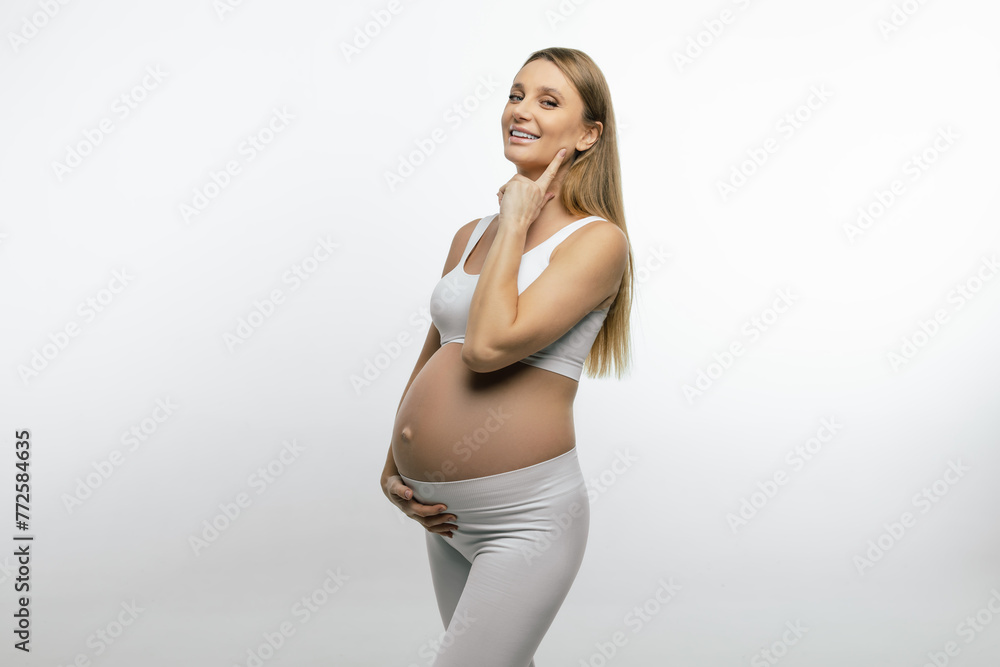 Pretty pregnant blonde woman feeling happy and joyful Pretty pregnant blonde woman feeling happy and joyful