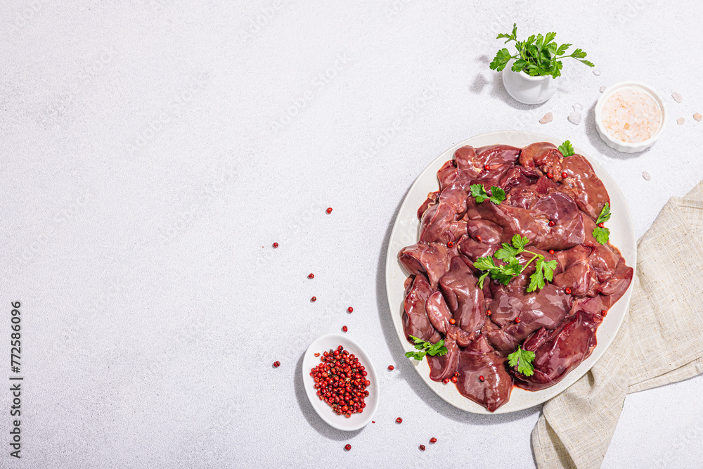 Raw chicken liver on stone background. Fresh ingredients ready for cooking, parsley, red pepper Raw chicken liver on stone background. Fresh ingredients ready for cooking, parsley, red pepper