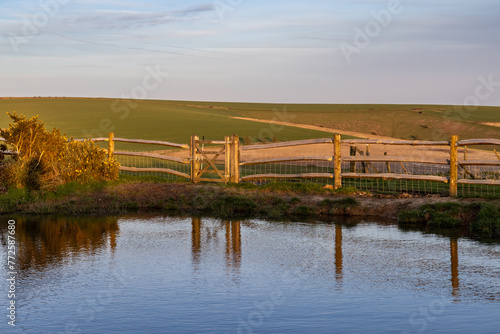 A dew pond surrounded by a wooden fence, on Ditchling Beacon in Sussex