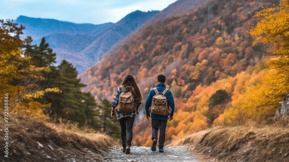 Fall. Couple Backpackers hiking on the path in mountains