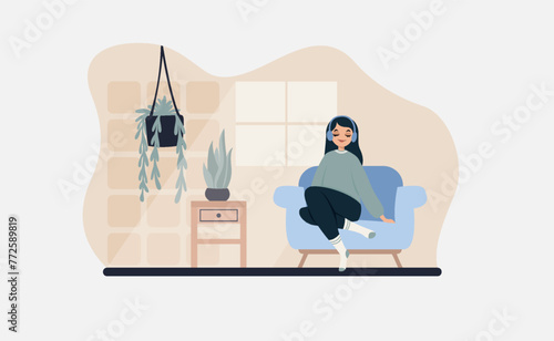 A girl sits on the sofa and listens to music on headphones.