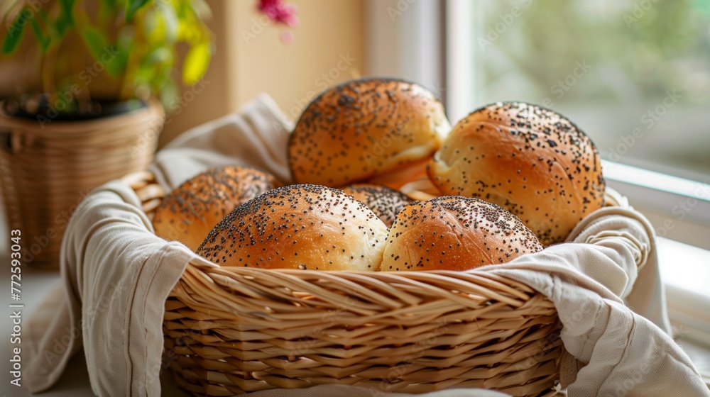 Delicious fragrant rolls with poppy seeds in a basket in a bright kitchen. Homemade buns baked for golden brown.