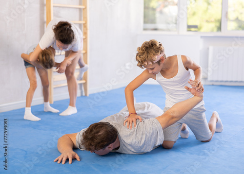 Father and son training self-defense techniques in studio..
