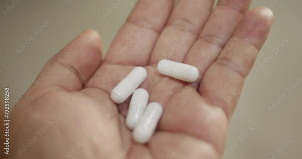 Close up shot of pills being poured into hand.
Close up shot of pills being poured into hand.