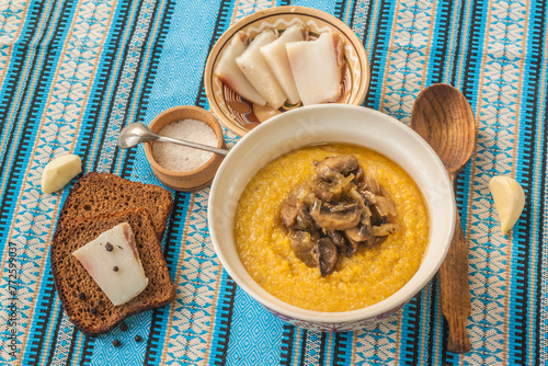 Banosh with toasted bacon and mushrooms. Hutsul lunch. Flat lay photo