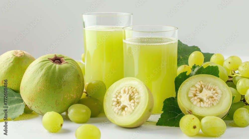 glass of green guava juice and green grapes on white background. glass of green guava juice and green grapes on white background.