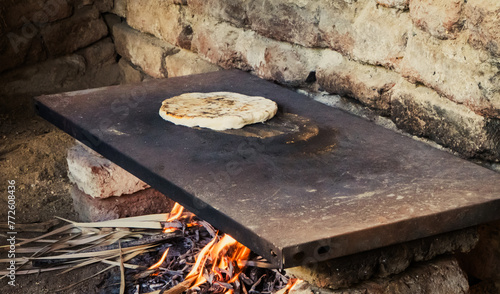 Egyptian flat bread cooking on open stove in a farmer's outdoor kitchen area
