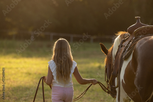 Little Girls with Horses riding western quarter horse and paint horse cowgirls in pink having fun walking away