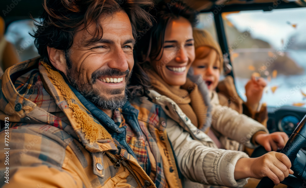 Man and woman sitting in vehicle smiling and waving at the camera.