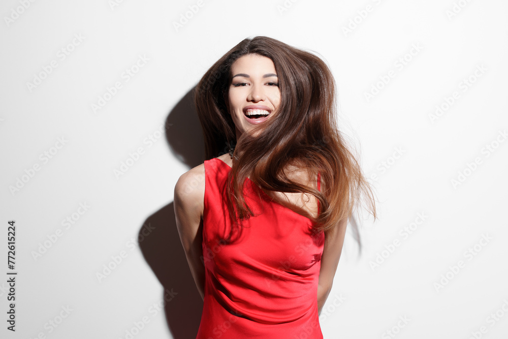 A vibrant image of a joyful young woman wearing a bright red dress against a white background, laughing with her hair flowing freely, exuding happiness and confidence. A vibrant image of a joyful young woman wearing a bright red dress against a white background, laughing with her hair flowing freely, exuding happiness and confidence.