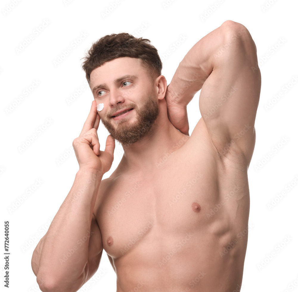 Handsome man applying moisturizing cream onto his face on white background Handsome man applying moisturizing cream onto his face on white background