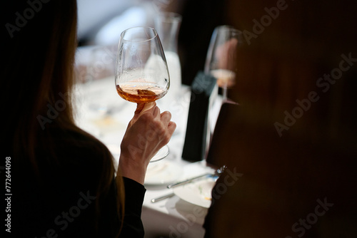 people hold glasses of white and red wine in a night restaurant, celebrating