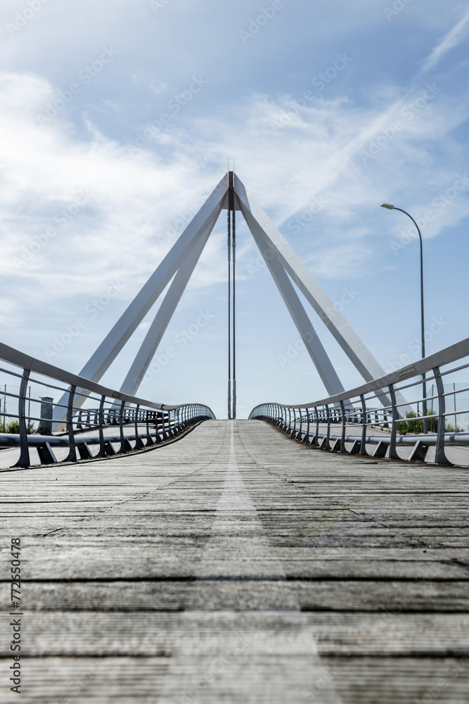 Metal structure of a small bridge with metal suspension structure, walkways and wooden floors for pedestrians Metal structure of a small bridge with metal suspension structure, walkways and wooden floors for pedestrians
