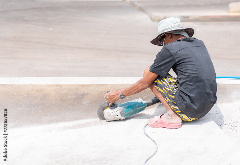 Worker cutting the concrete slab with electric circular saw and dust fly arround. Worker cutting the concrete slab with electric circular saw and dust fly arround.