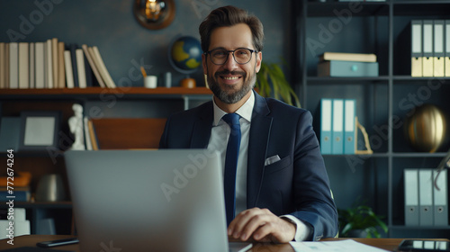 Young handsome businessman using laptop at his office desk.