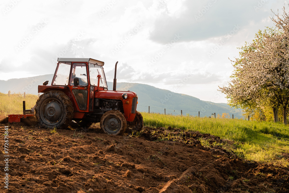 Fototapeta premium Tractor sowing crops at agricultural fields in spring.