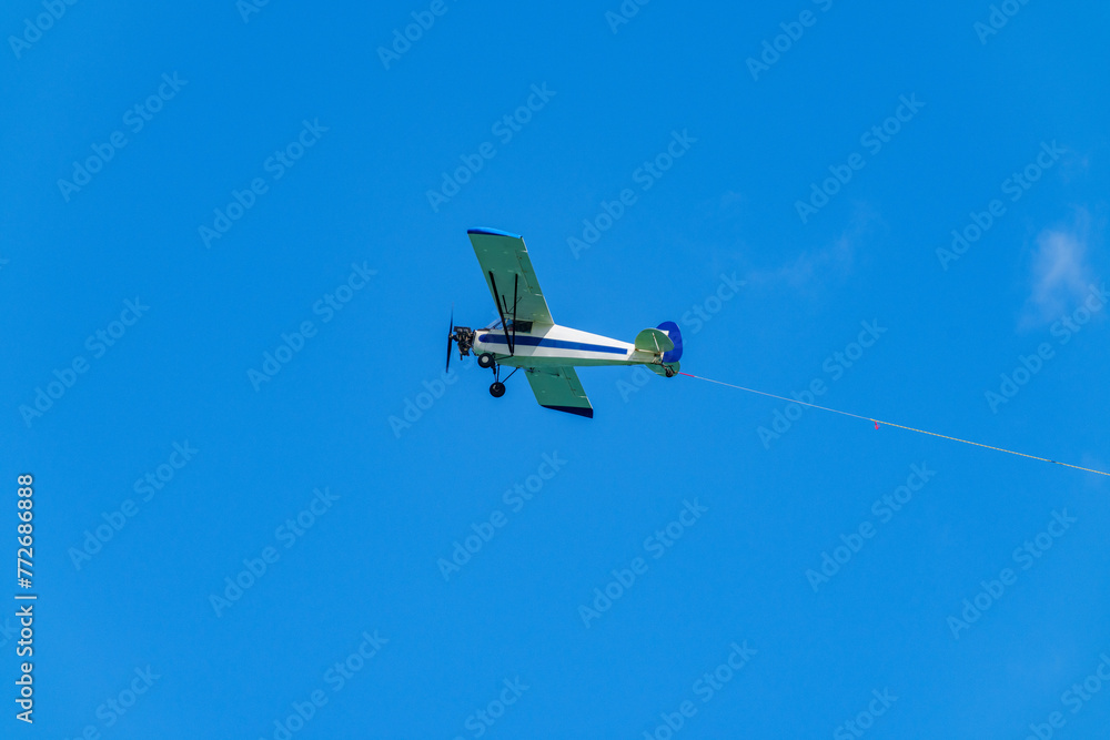Aerial advertising banner airplane on a blue sky with visible ro - obrazy, fototapety, plakaty 