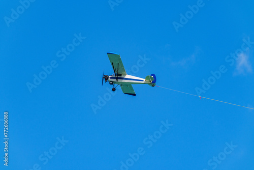 Aerial advertising banner airplane on a blue sky with visible ro