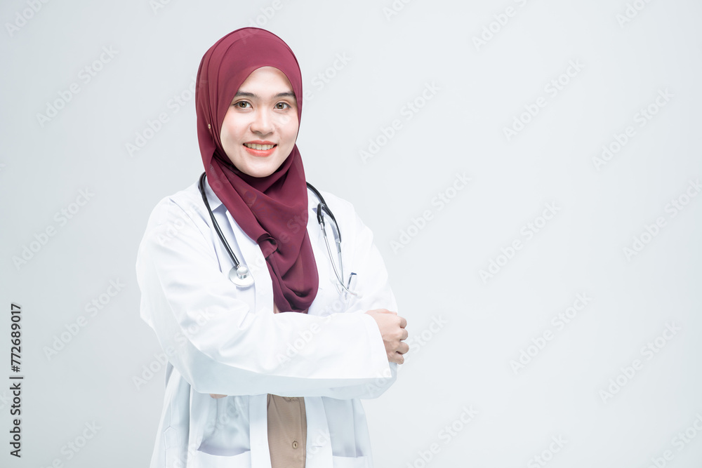 Happy beautiful asian Muslim woman doctor in medical coat standing with crossed arms, and with a smiley face ready to serve, on white background. Happy beautiful asian Muslim woman doctor in medical coat standing with crossed arms, and with a smiley face ready to serve, on white background.