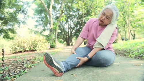 Elderly woman exercising and running too fast caused her knee to twist. Sitting with sudden pain in the knee, tendonitis, severe pain, had to stop running and scream in pain. photo