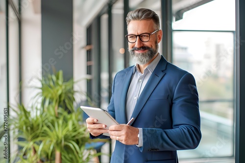 Caucasian man holding tablet phone in office