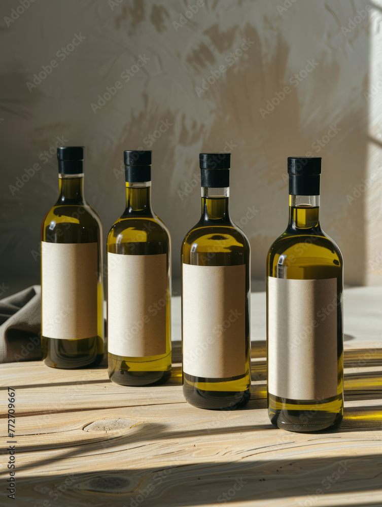 Group of four glass bottles with various colored blank labels on a wooden surface showing possible product lineup Group of four glass bottles with various colored blank labels on a wooden surface showing possible product lineup