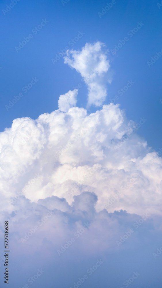 White fluffy clouds open for fantasy idea shape against bright blue sky for background with copy space, graphic resource, cloud motion from the wind White fluffy clouds open for fantasy idea shape against bright blue sky for background with copy space, graphic resource, cloud motion from the wind