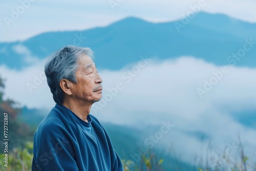 Asian man enjoying the fresh morning air on the mountain, calming refreshing
