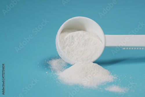 Close up of baby milk powder and spoon on tile background.