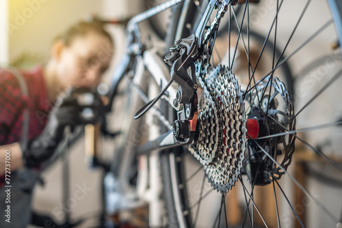 Woman is performing maintenance on mountain bike. Concept of fixing and preparing the bicycle for the new season