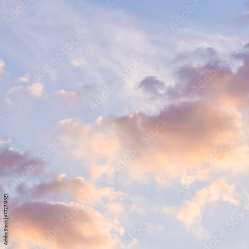 Blue sky background with pale pink clouds at sunset