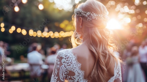 A woman in a wedding dress standing in front of a crowd at a sunset wedding ceremony