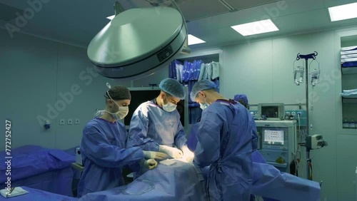 A team of doctors - surgeons performing a surgical operation in the operating room of a modern hospital department. Healthcare and medicine.
