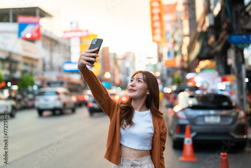 Young Asian tourists standing selfie taking a photo. Young woman beautiful tourists in Chinatown street food market, Bangkok, Thailand
