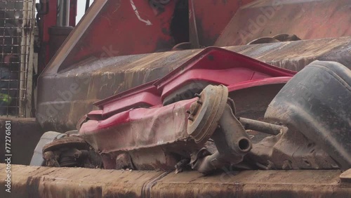 A car being crushed by a car crusher in a junkyard. photo