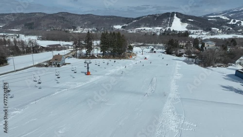 Fast tracking shot flying down mountain following cable car chair lift, skiers skiing down the slopes below. Japan Ski Snow Run, Hakuba and Myoko region photo