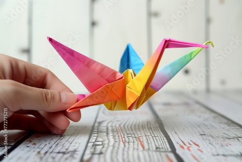 hand folding colorful origami paper crane photo