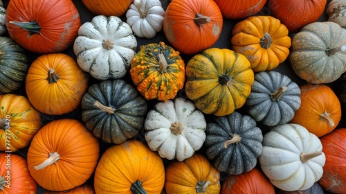   A stack of orange and white pumpkins with several pumpkins piled on top